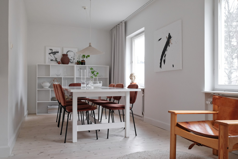 Inspiration for a scandinavian dining room in Stockholm with white walls, light hardwood floors and beige floor.