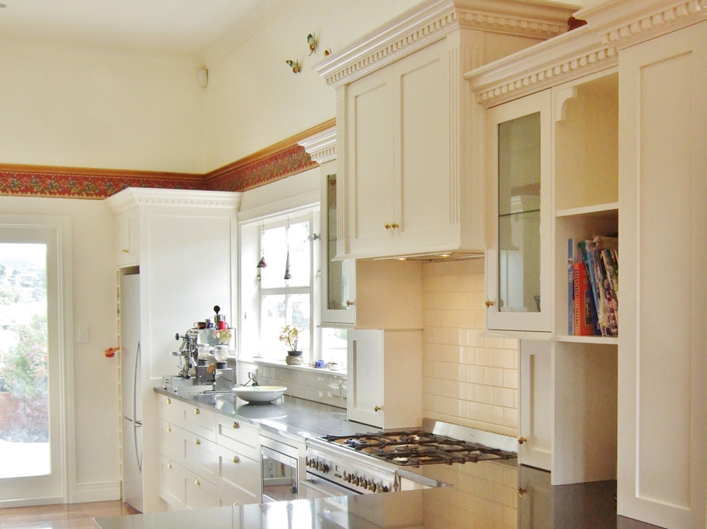 This is an example of a traditional kitchen in Wellington with ceramic splashback and medium hardwood floors.