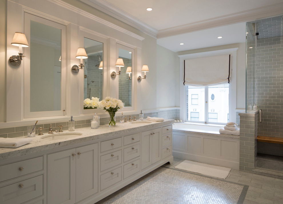 Large traditional master bathroom in San Francisco with white walls, an undermount tub, recessed-panel cabinets, white cabinets, an alcove shower, gray tile, subway tile, mosaic tile floors, an undermount sink, grey floor, a hinged shower door and marble benchtops.