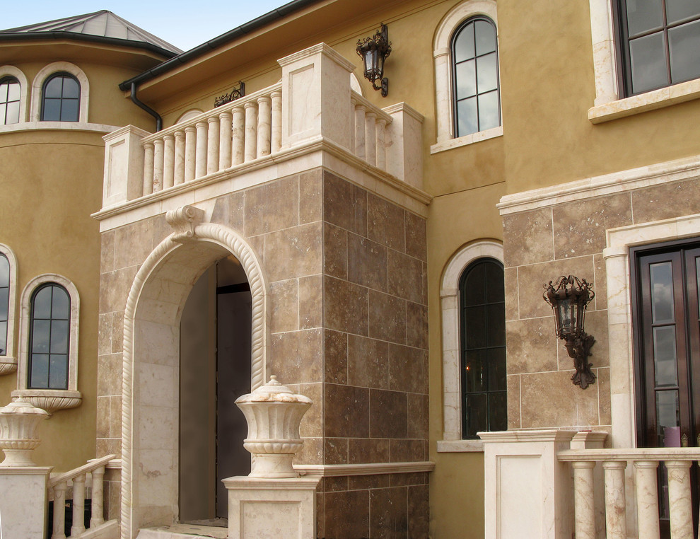 Expansive mediterranean two-storey exterior in Other with stone veneer.