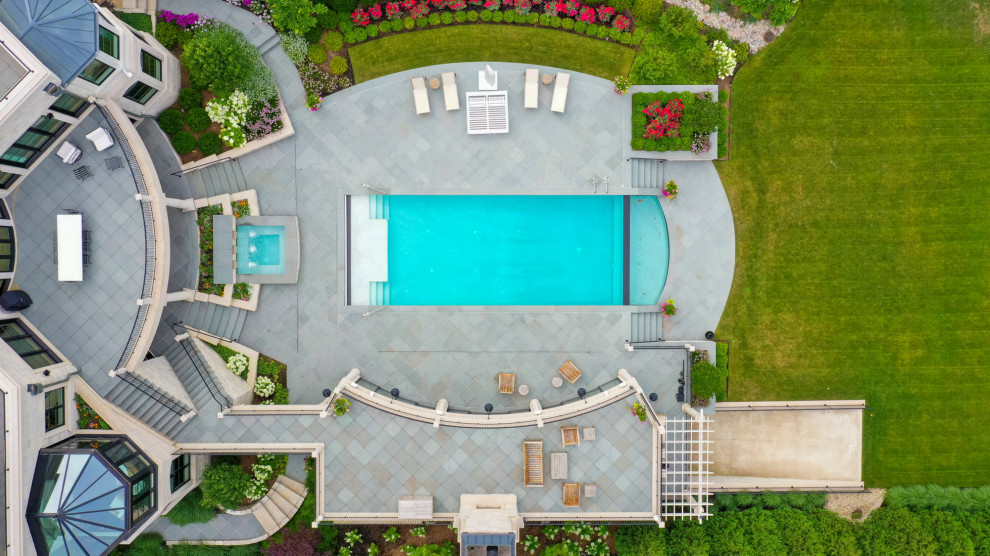 Immagine di una piscina monocorsia chic rettangolare di medie dimensioni e in cortile con paesaggistica bordo piscina e pavimentazioni in pietra naturale