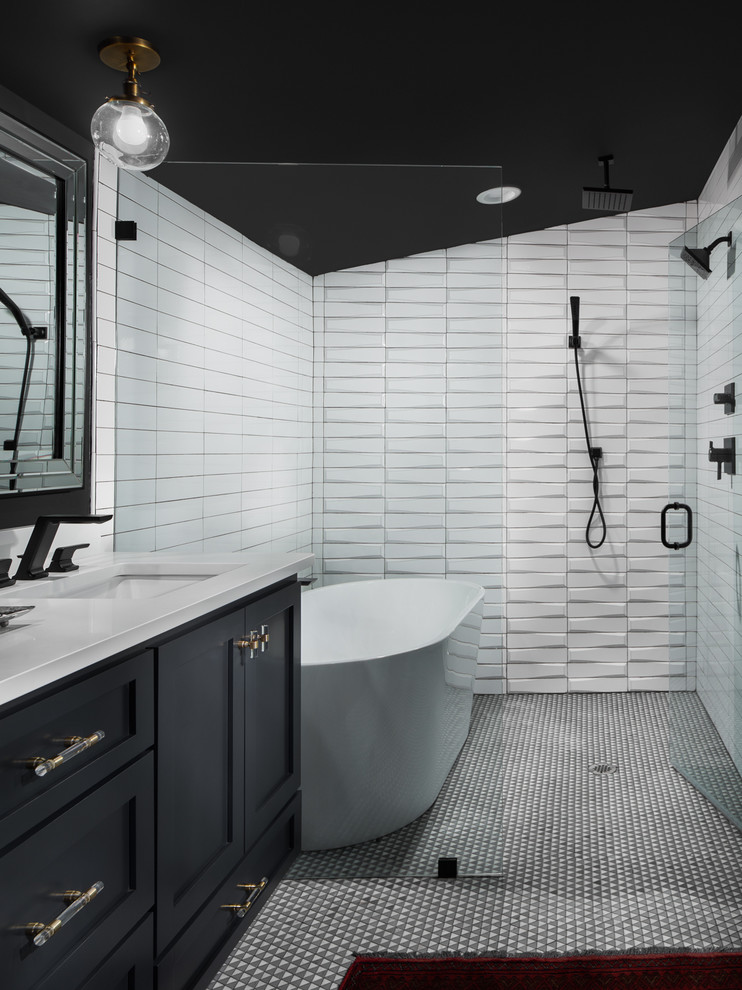 Photo of a small transitional master wet room bathroom in Birmingham with recessed-panel cabinets, black cabinets, a freestanding tub, a two-piece toilet, white tile, ceramic tile, black walls, ceramic floors, an undermount sink, engineered quartz benchtops, grey floor, a hinged shower door and white benchtops.