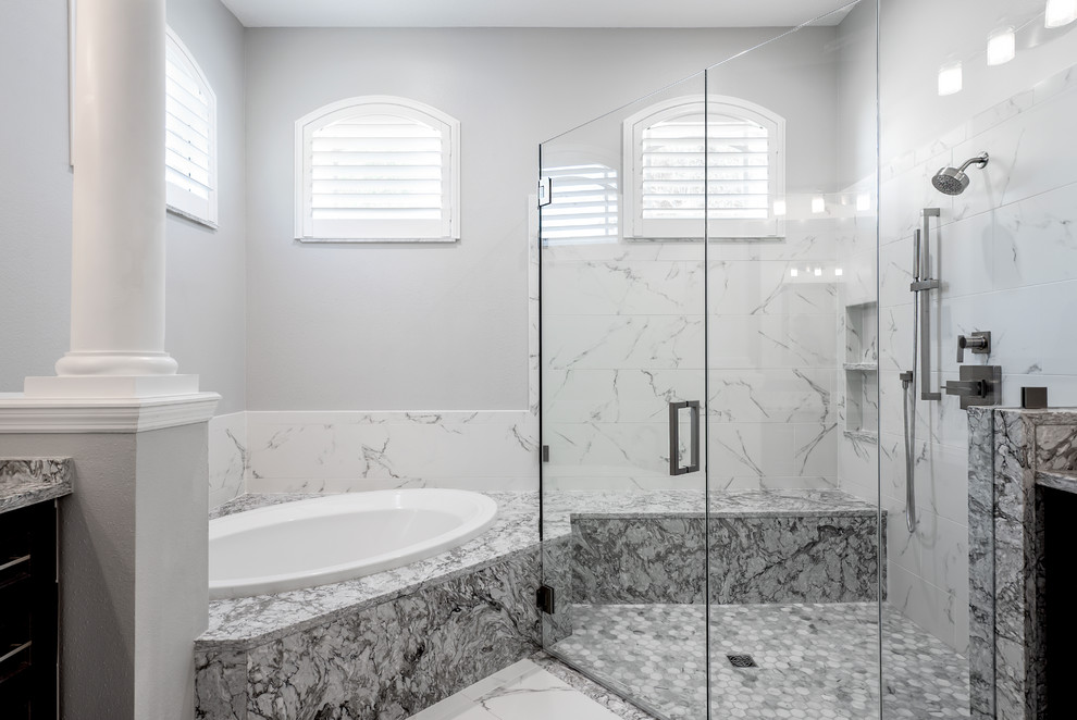 Large traditional master bathroom in Tampa with shaker cabinets, brown cabinets, a drop-in tub, a curbless shower, a two-piece toilet, white tile, porcelain tile, grey walls, porcelain floors, an undermount sink, engineered quartz benchtops, white floor, a hinged shower door and grey benchtops.