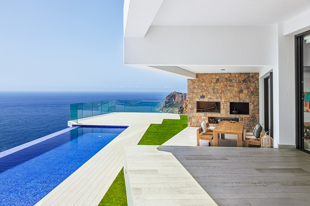 Design ideas for a large contemporary deck in Alicante-Costa Blanca with a roof extension.