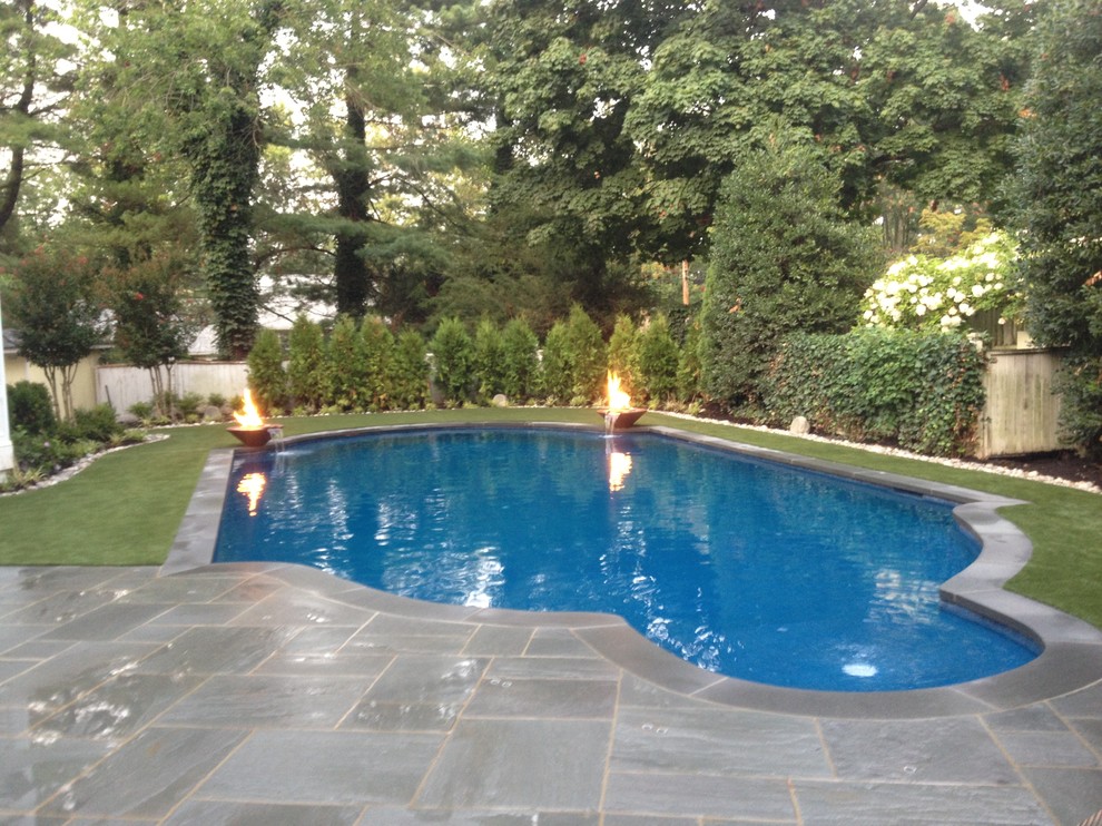 Inspiration for a mid-sized traditional backyard custom-shaped pool in New York with a water feature and natural stone pavers.