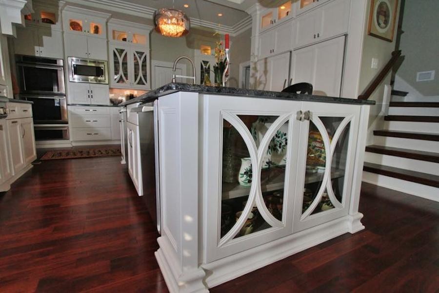 Enclosed kitchen - mid-sized transitional u-shaped dark wood floor enclosed kitchen idea with a drop-in sink, flat-panel cabinets, white cabinets, granite countertops, white backsplash, stainless steel appliances and an island