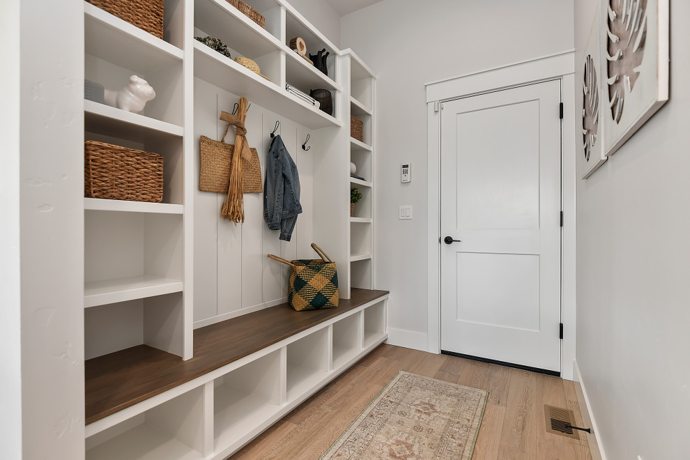 This is an example of a mid-sized arts and crafts hallway in Boise with beige walls, light hardwood floors, brown floor and planked wall panelling.
