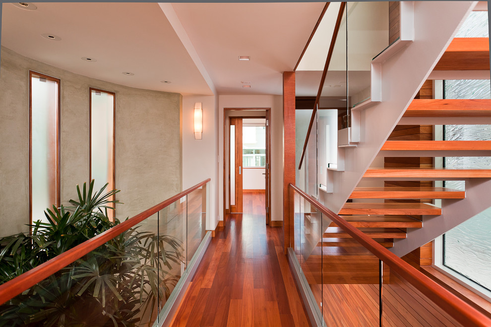 Mid-sized contemporary hallway in Los Angeles with multi-coloured walls, medium hardwood floors and red floor.