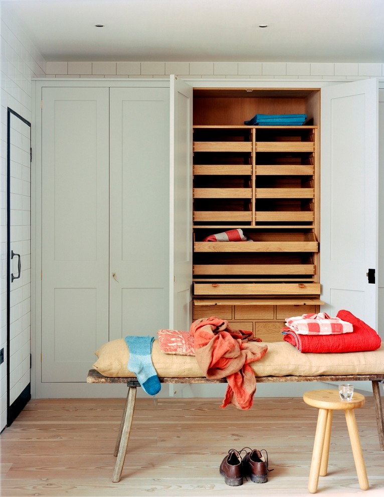 Inspiration for a transitional storage and wardrobe in London with light hardwood floors.