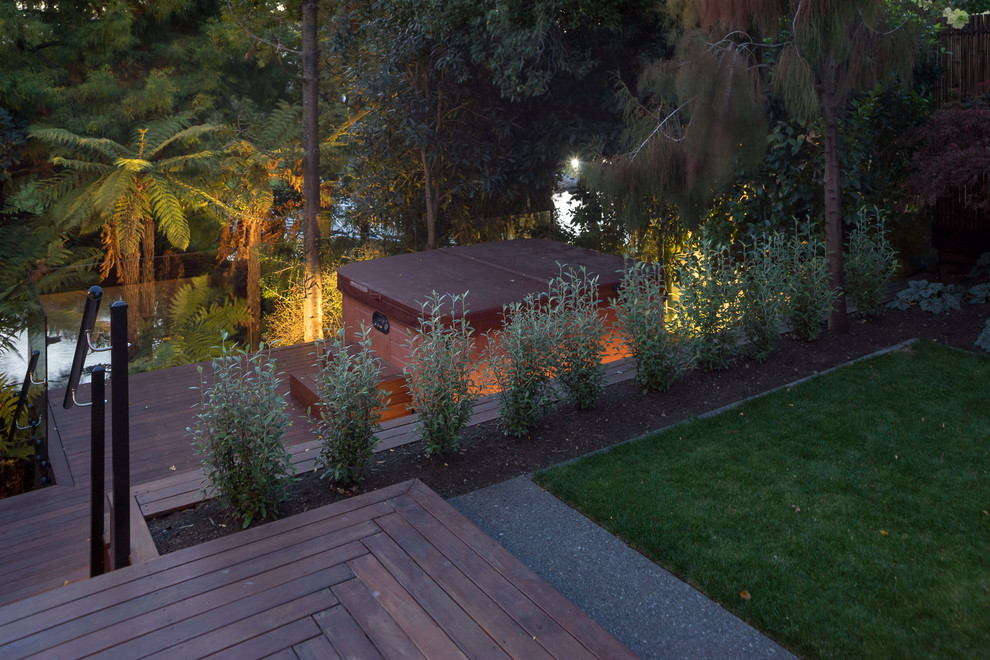 Photo of a small contemporary side yard formal garden in Christchurch with a retaining wall and decking.