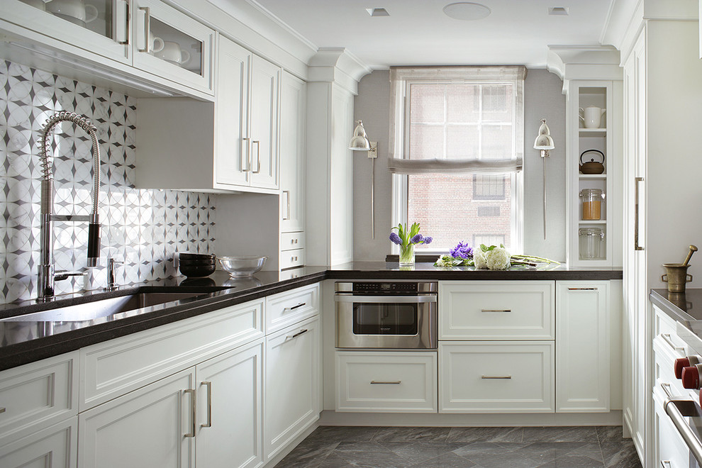 This is an example of a small traditional u-shaped kitchen in New York with an undermount sink, recessed-panel cabinets, white cabinets, onyx benchtops, white splashback, mosaic tile splashback, stainless steel appliances, ceramic floors and no island.