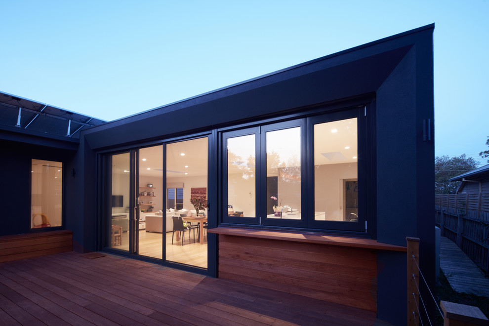 This is an example of a contemporary one-storey black exterior in Melbourne with concrete fiberboard siding and a flat roof.