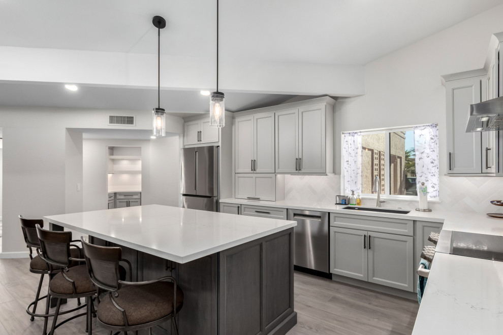 Eat-in kitchen - mid-sized transitional porcelain tile and gray floor eat-in kitchen idea in Phoenix with an undermount sink, shaker cabinets, gray cabinets, quartz countertops, white backsplash, subway tile backsplash, stainless steel appliances, an island and white countertops