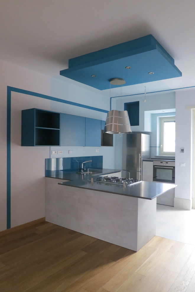 This is an example of a small contemporary u-shaped open plan kitchen in Turin with an undermount sink, flat-panel cabinets, grey cabinets, quartz benchtops, stainless steel appliances, light hardwood floors, a peninsula and turquoise benchtop.