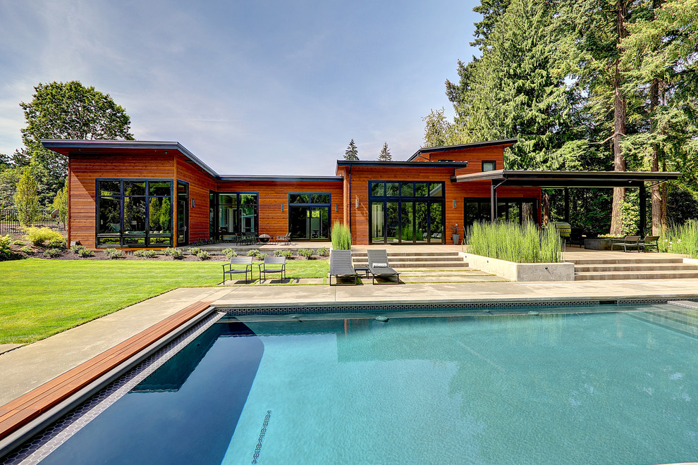 Inspiration for a large contemporary backyard rectangular pool in Portland with concrete pavers.
