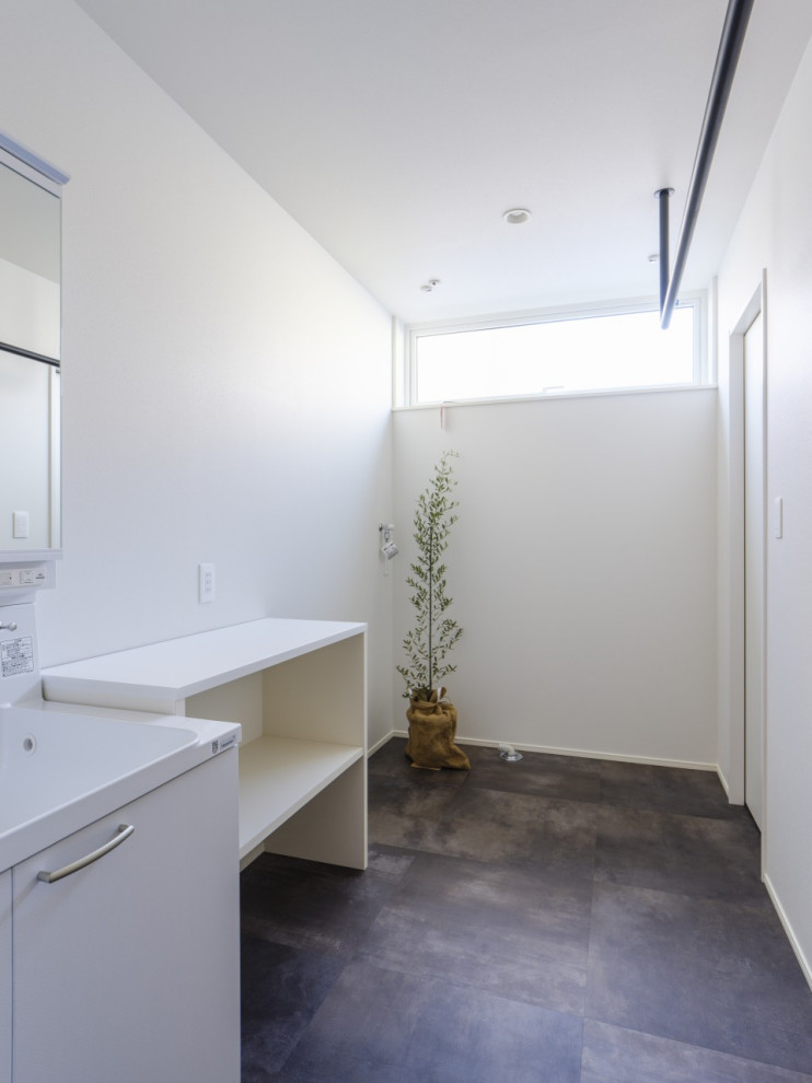 Foto på en mellanstor funkis vita linjär tvättstuga enbart för tvätt, med öppna hyllor, vita skåp, träbänkskiva, vita väggar, målat trägolv och svart golv
