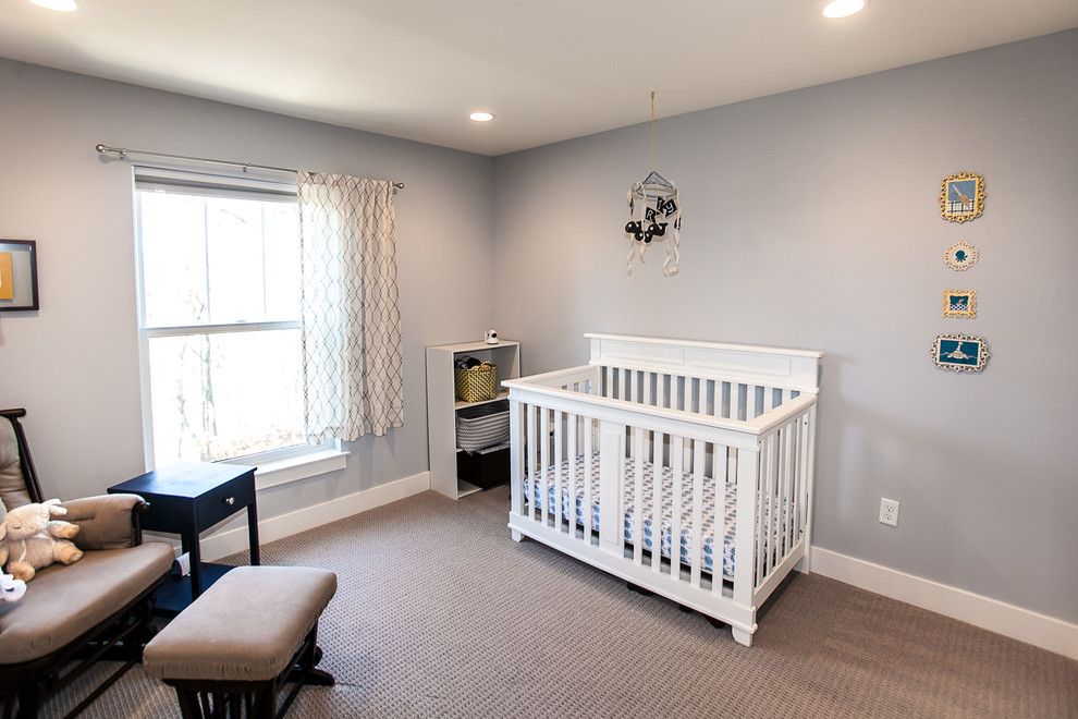Large arts and crafts gender-neutral nursery in St Louis with grey walls and carpet.