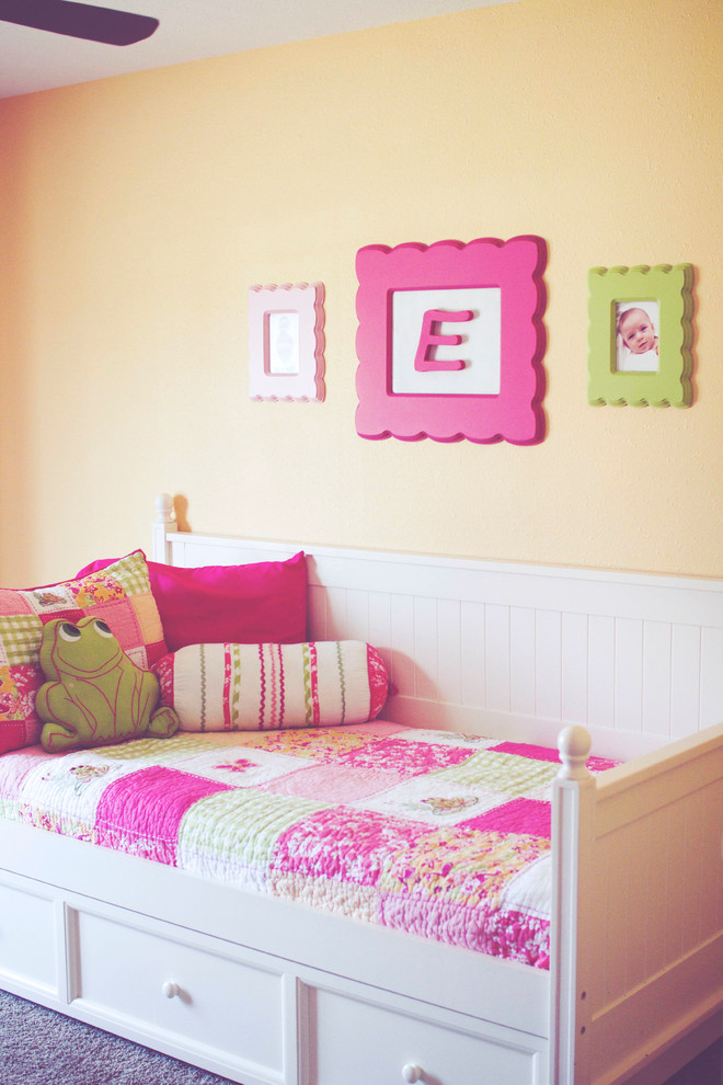 This is an example of a mid-sized country kids' bedroom for kids 4-10 years old and girls in Milwaukee with orange walls.