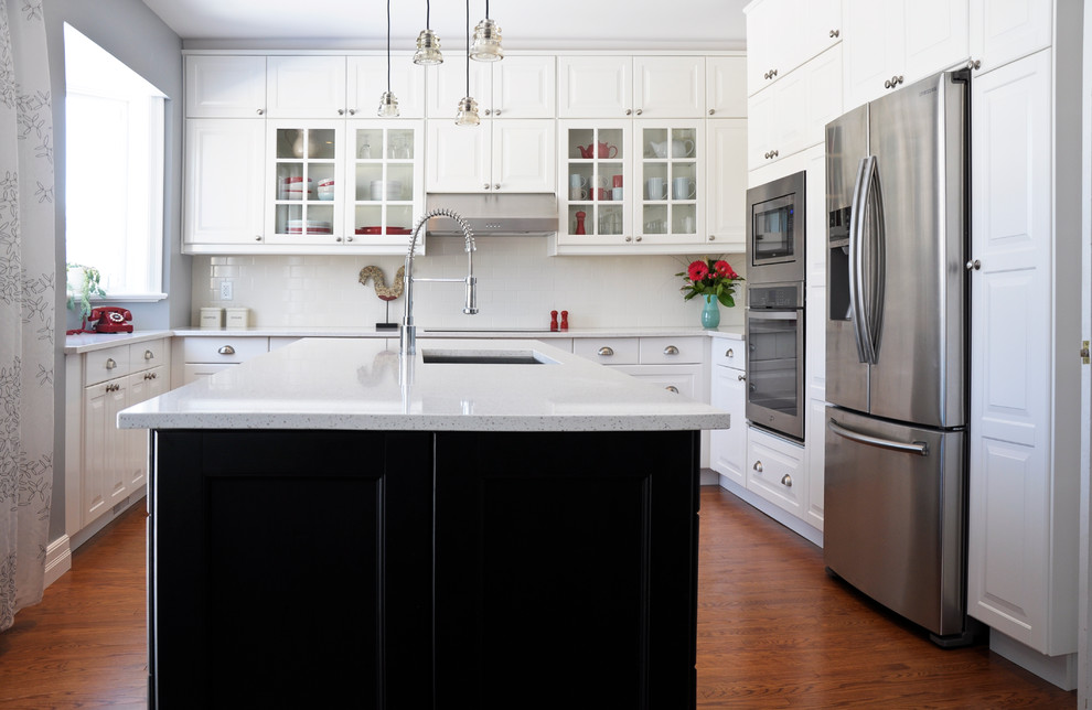 Transitional eat-in kitchen photo in Ottawa with an undermount sink, raised-panel cabinets, white cabinets, quartz countertops, white backsplash, porcelain backsplash, stainless steel appliances and an island