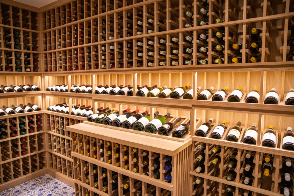 Bild på en mellanstor medelhavsstil vinkällare, med klinkergolv i porslin, vinhyllor och blått golv