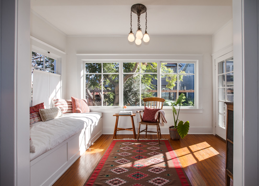 Photo of a beach style entryway in Los Angeles with white walls, medium hardwood floors and brown floor.