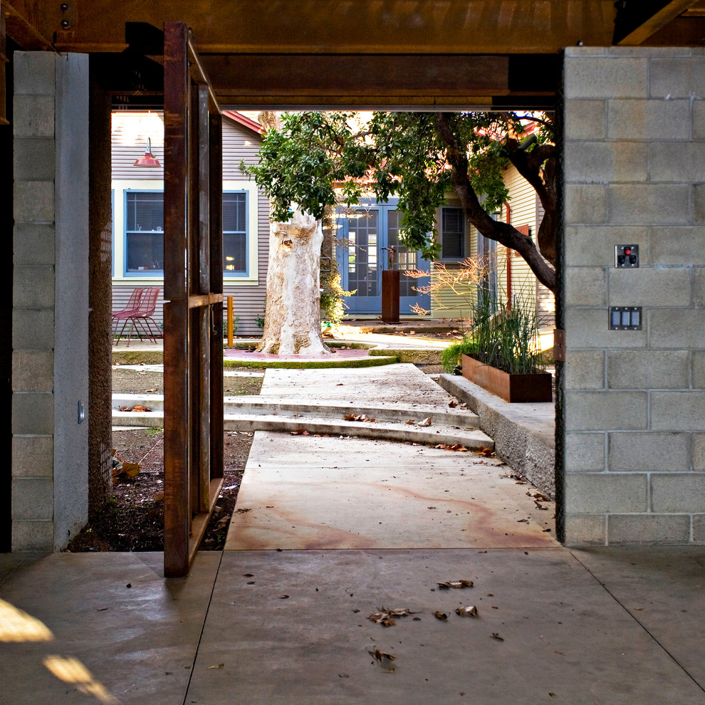 Industrial entryway in Sacramento with a pivot front door and a metal front door.