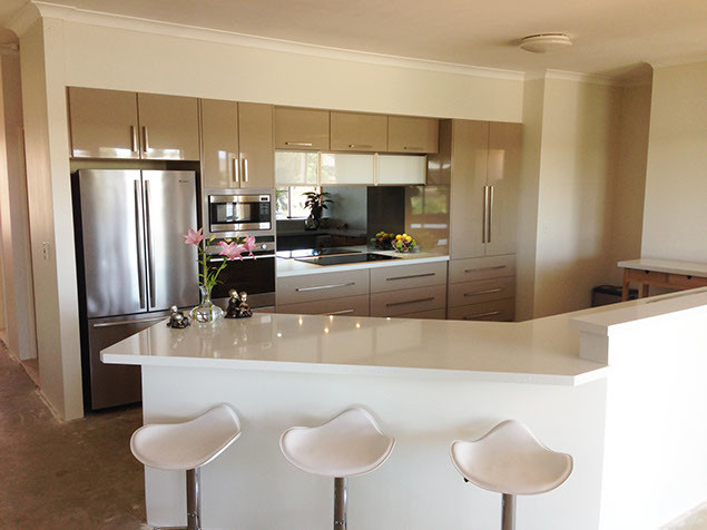 Contemporary single-wall eat-in kitchen in Perth with an undermount sink, raised-panel cabinets, beige cabinets, quartz benchtops, black splashback, glass sheet splashback, stainless steel appliances, cement tiles and no island.