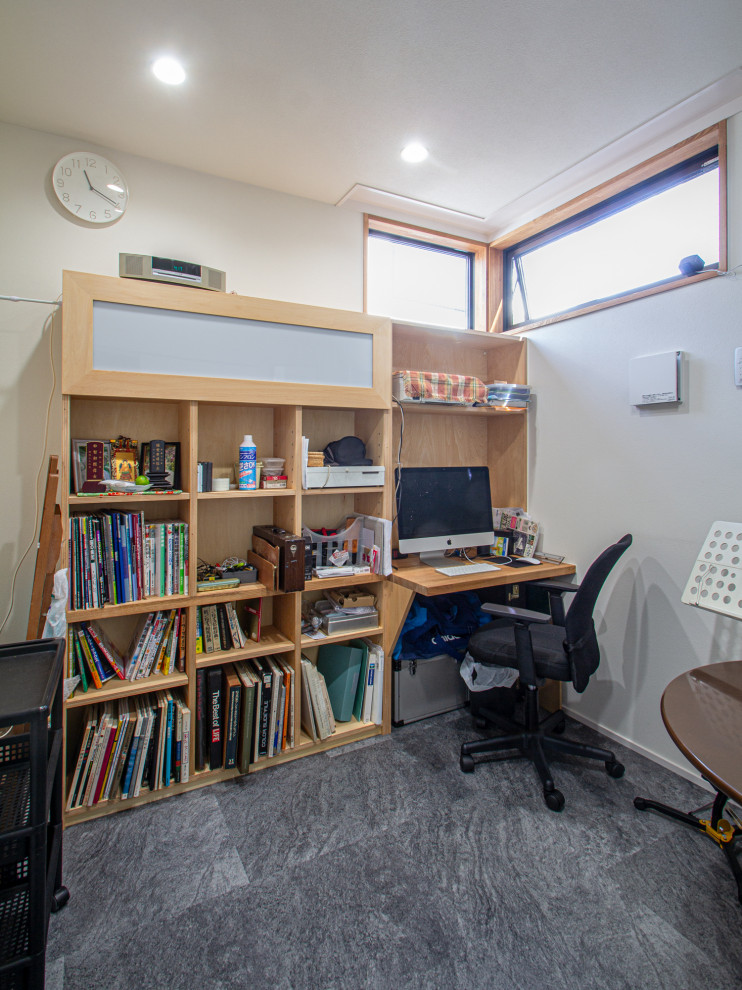 Exempel på ett mellanstort industriellt hemmastudio, med vita väggar, linoleumgolv, ett inbyggt skrivbord och svart golv
