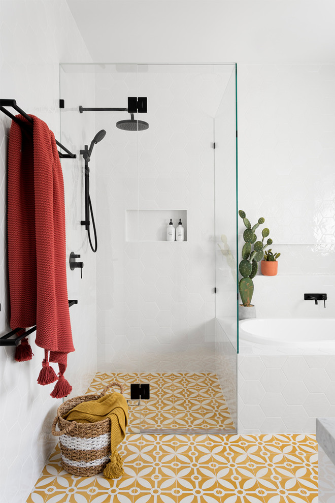 Inspiration for a large contemporary master bathroom in Melbourne with a drop-in tub, a corner shower, white tile, ceramic tile, cement tiles, yellow floor, a hinged shower door, flat-panel cabinets, white cabinets, a one-piece toilet, white walls, a vessel sink and marble benchtops.