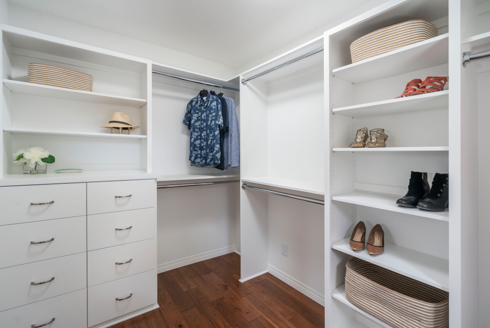 Inspiration for a mid-sized transitional gender-neutral walk-in wardrobe in Los Angeles with shaker cabinets, white cabinets, medium hardwood floors and brown floor.