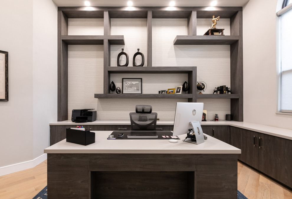 Ejemplo de sala de manualidades minimalista grande con paredes marrones, suelo de madera clara, escritorio independiente, suelo gris y papel pintado
