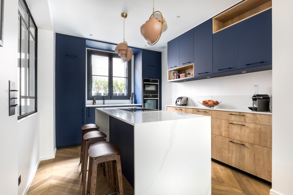 Idéer för ett avskilt modernt flerfärgad kök, med en undermonterad diskho, släta luckor, blå skåp, bänkskiva i kvarts, vitt stänkskydd, integrerade vitvaror, mellanmörkt trägolv, en köksö och brunt golv