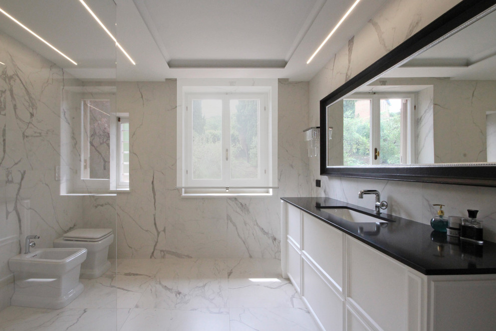Design ideas for a large traditional 3/4 bathroom in Milan with recessed-panel cabinets, white cabinets, an open shower, a two-piece toilet, marble, white walls, marble floors, an integrated sink, marble benchtops, white floor and black benchtops.