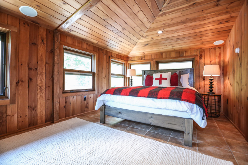 Country bedroom in New York with brown walls, brown floor, vaulted, wood and wood walls.
