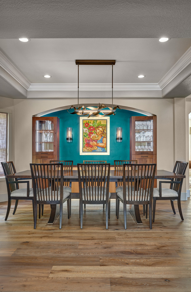 Design ideas for a mid-sized contemporary dining room in Sacramento with multi-coloured walls, medium hardwood floors, a standard fireplace, multi-coloured floor and panelled walls.
