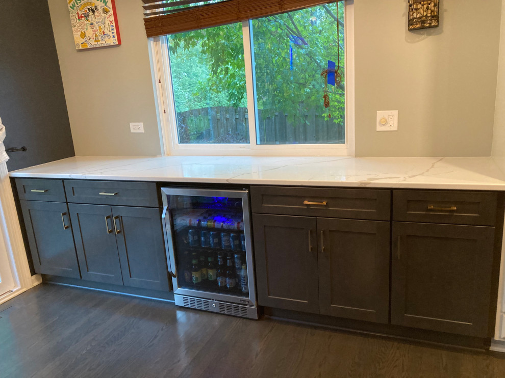 Cette photo montre une petite cuisine linéaire chic avec un placard à porte shaker, des portes de placard grises et un plan de travail en quartz modifié.