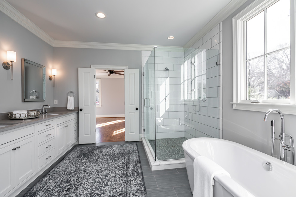 Inspiration for a transitional master bathroom in Other with recessed-panel cabinets, white cabinets, a freestanding tub, a corner shower, yellow tile, grey walls, an undermount sink, grey floor, a hinged shower door and grey benchtops.