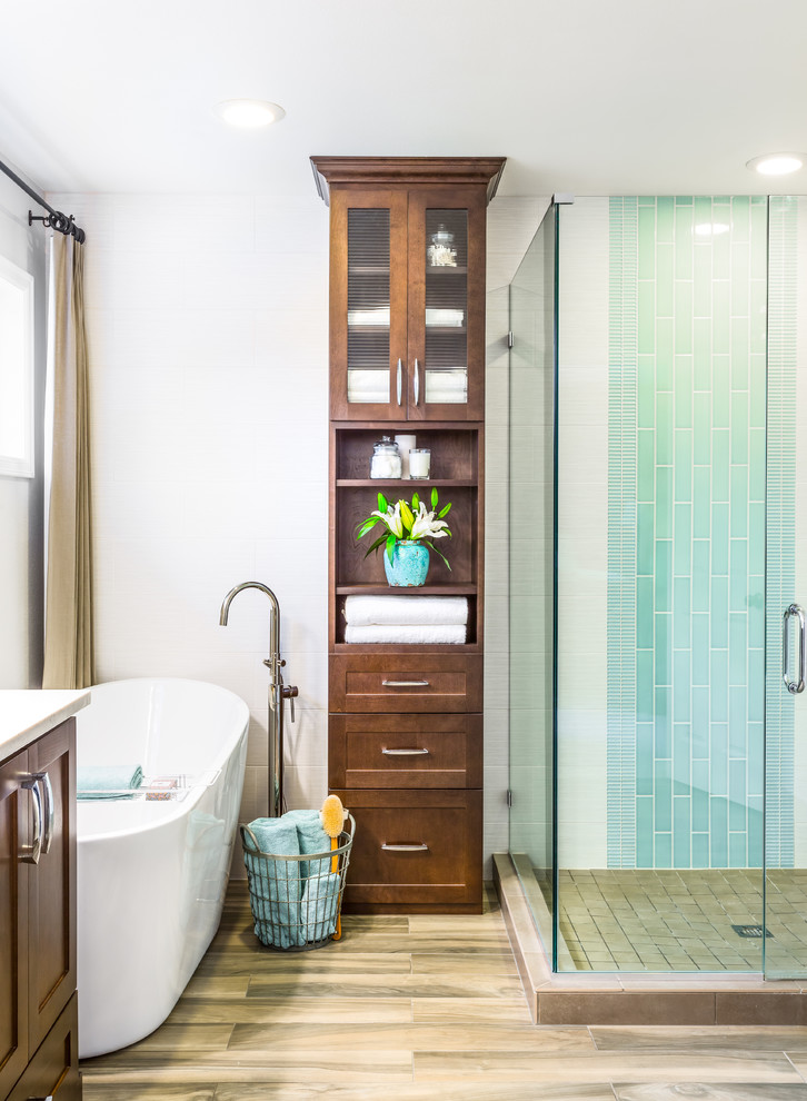 Inspiration for a mid-sized transitional master bathroom in Seattle with an undermount sink, recessed-panel cabinets, dark wood cabinets, a freestanding tub, a corner shower, a two-piece toilet, blue tile, white walls and porcelain floors.