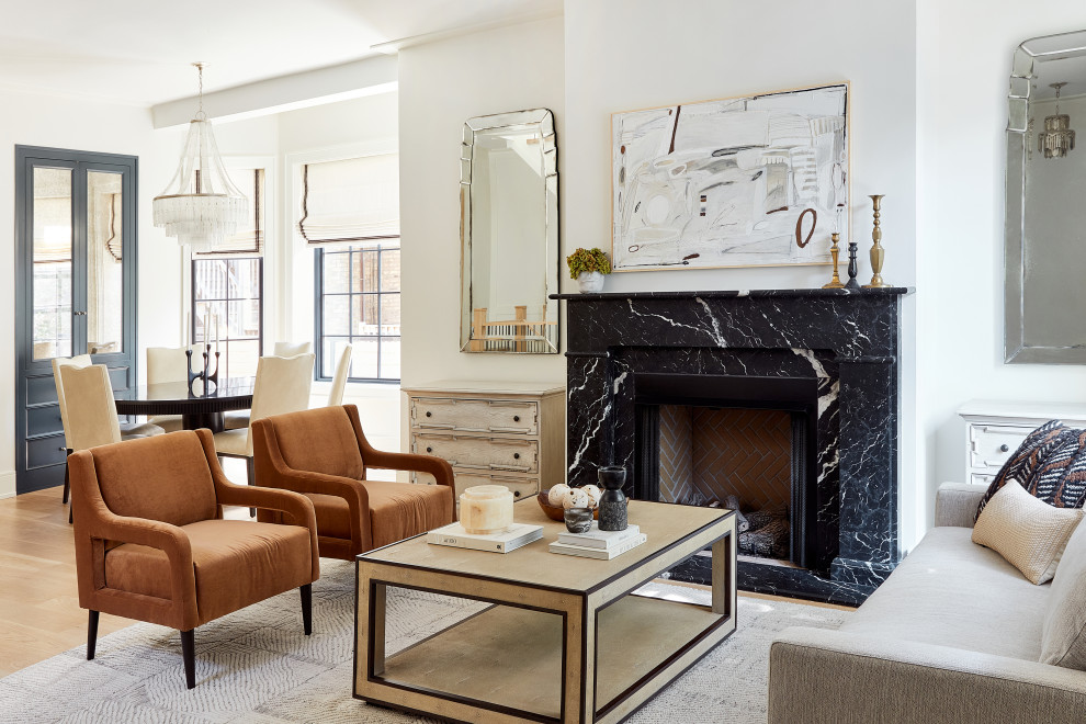 This is an example of a transitional open concept living room in Chicago with white walls, medium hardwood floors, a standard fireplace, a stone fireplace surround, no tv and brown floor.