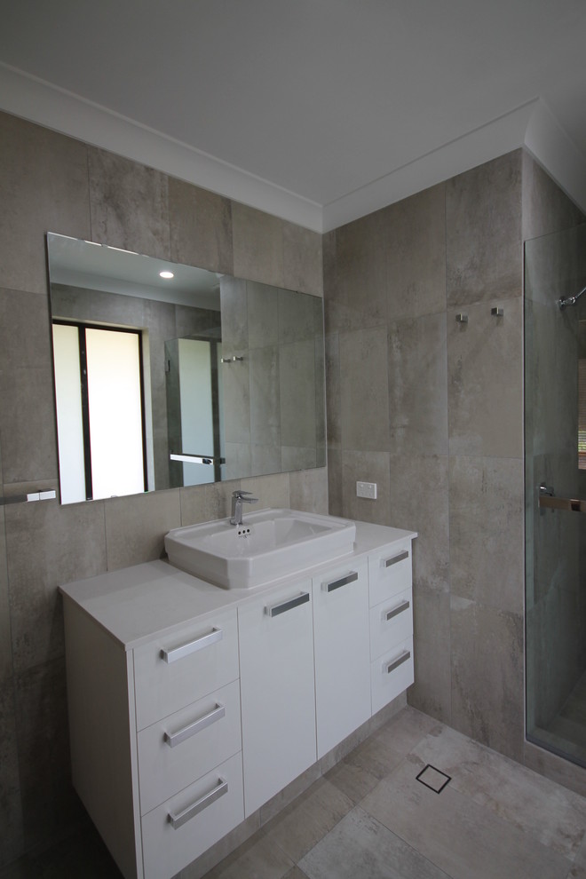 This is an example of a mid-sized industrial bathroom in Perth with flat-panel cabinets, white cabinets, multi-coloured tile, porcelain tile, porcelain floors and engineered quartz benchtops.