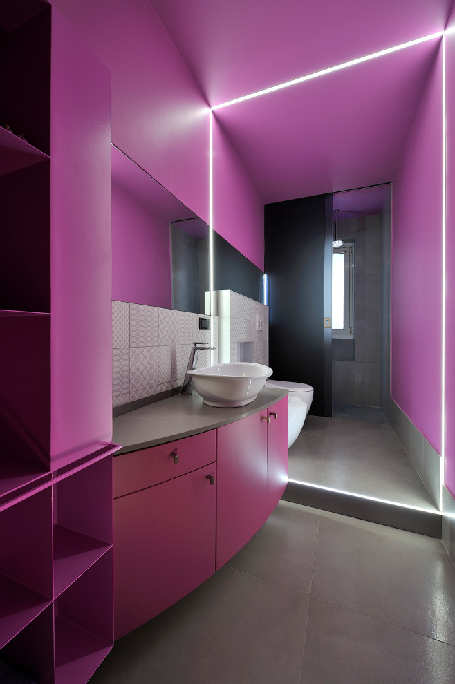 Inspiration for a small contemporary powder room in Other with a two-piece toilet, pink walls, a vessel sink, grey floor, grey benchtops and a floating vanity.
