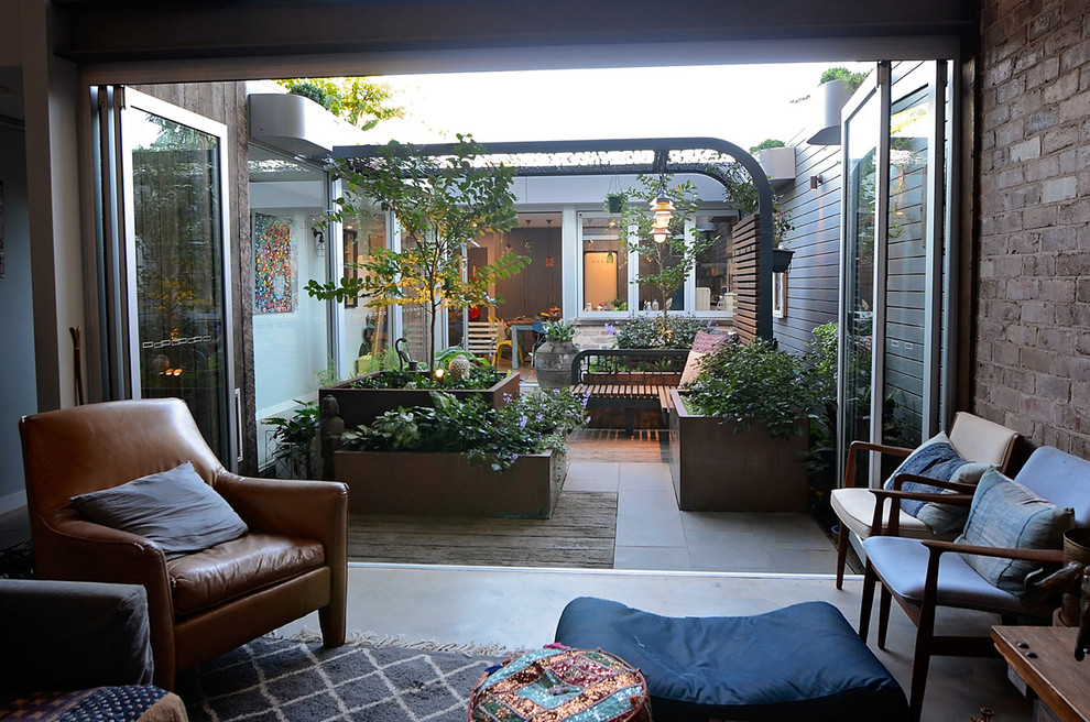 Design ideas for a small backyard patio in Sydney with a container garden, decking and a pergola.