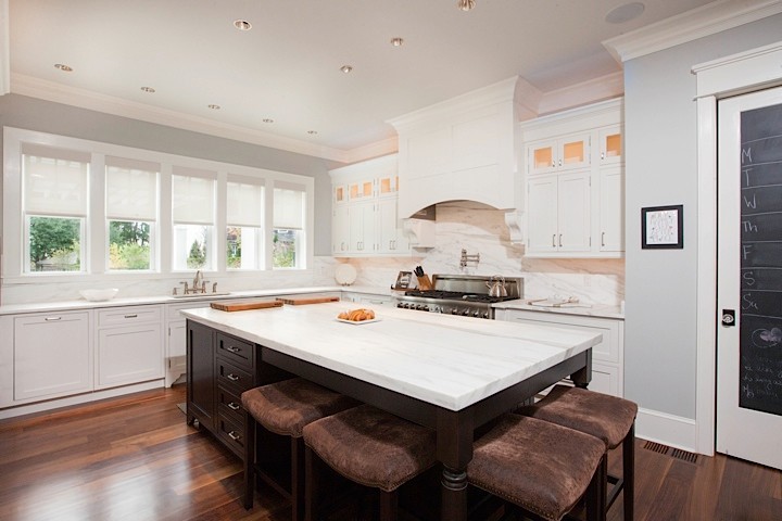 Inspiration for a traditional l-shaped eat-in kitchen in Bridgeport with an undermount sink, recessed-panel cabinets, white cabinets, marble benchtops, white splashback, stainless steel appliances, dark hardwood floors and with island.