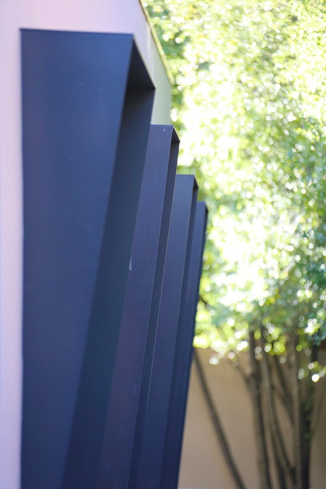 This is an example of a large contemporary two-storey multi-coloured house exterior in Melbourne with metal siding, a flat roof and a metal roof.