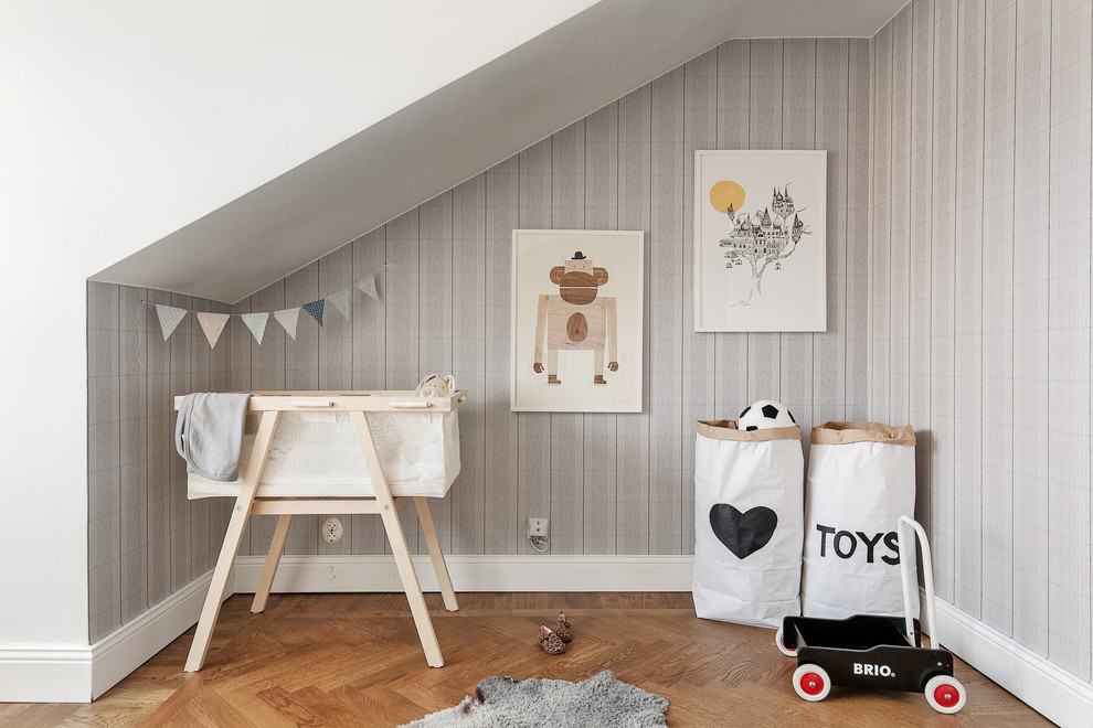 Photo of a small scandinavian gender-neutral nursery in Stockholm with multi-coloured walls and medium hardwood floors.