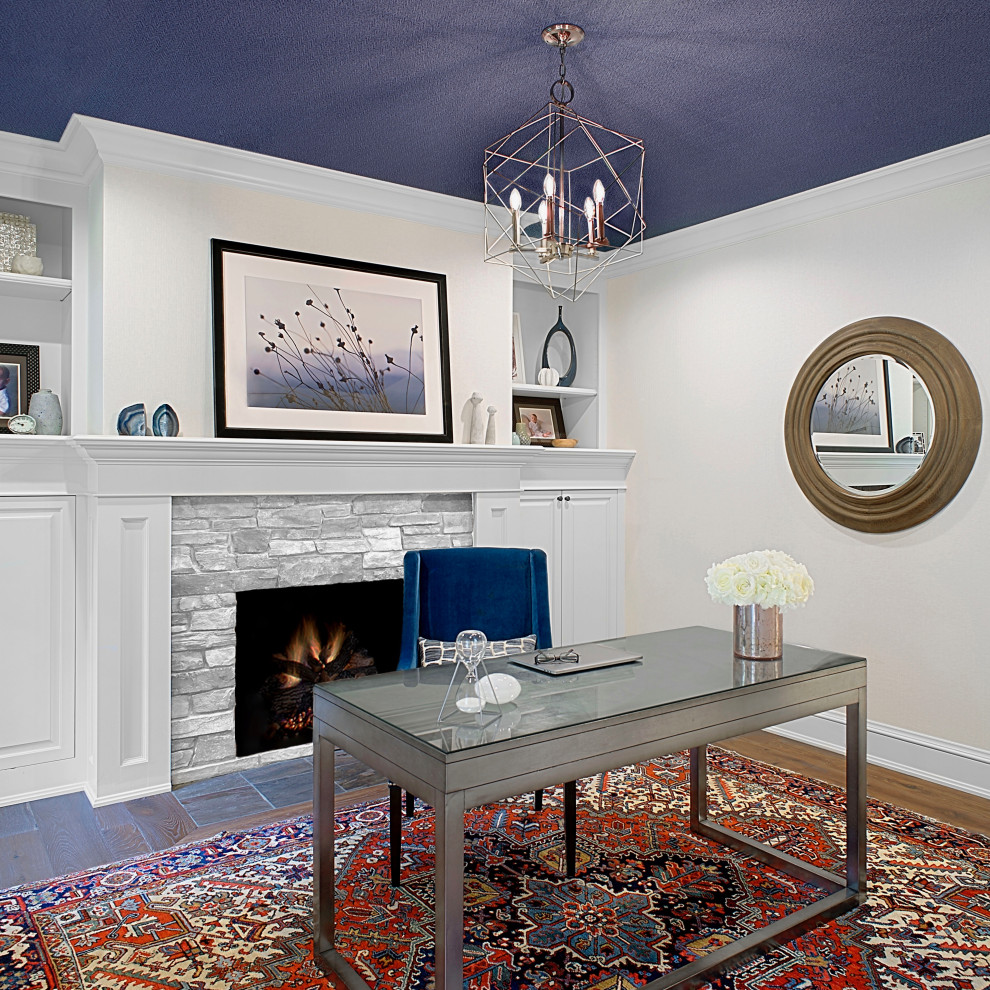 Design ideas for a large traditional study in Grand Rapids with white walls, medium hardwood flooring, a standard fireplace, a stacked stone fireplace surround, a freestanding desk, brown floors, a wallpapered ceiling and wallpapered walls.
