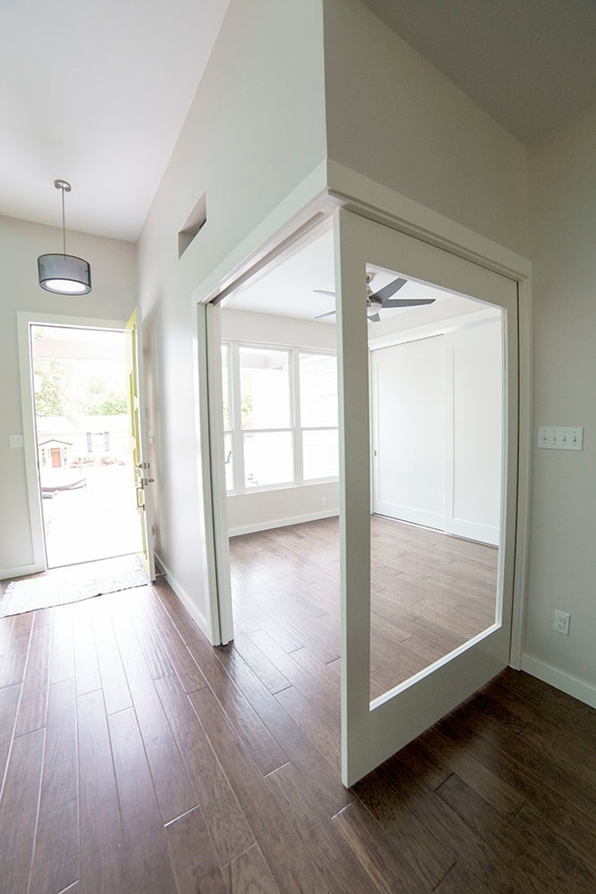 Photo of a mid-sized contemporary foyer in Austin with white walls, medium hardwood floors and a pivot front door.