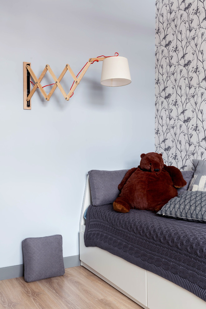 Design ideas for a contemporary gender-neutral kids' room for kids 4-10 years old in London with blue walls, medium hardwood floors and brown floor.