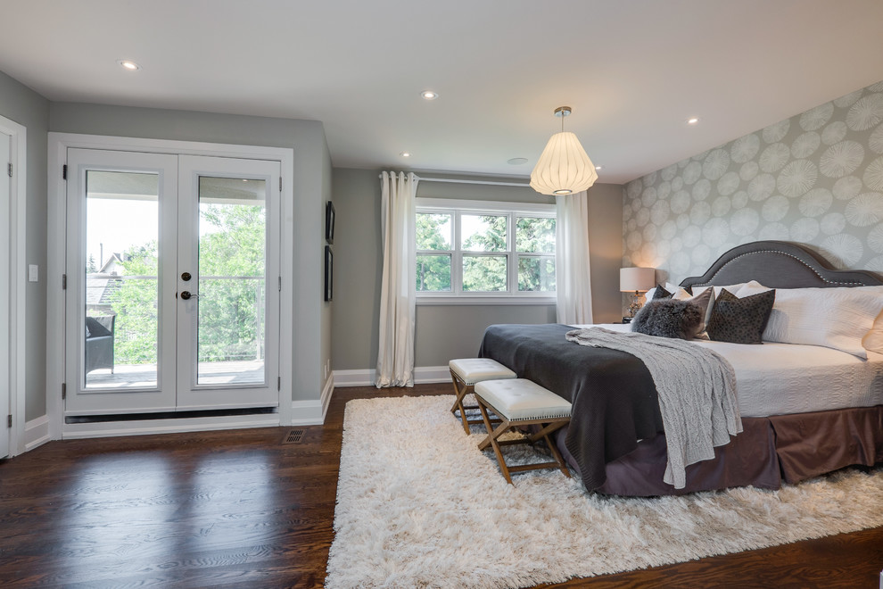 Large traditional master bedroom in Toronto with grey walls, dark hardwood floors and a standard fireplace.