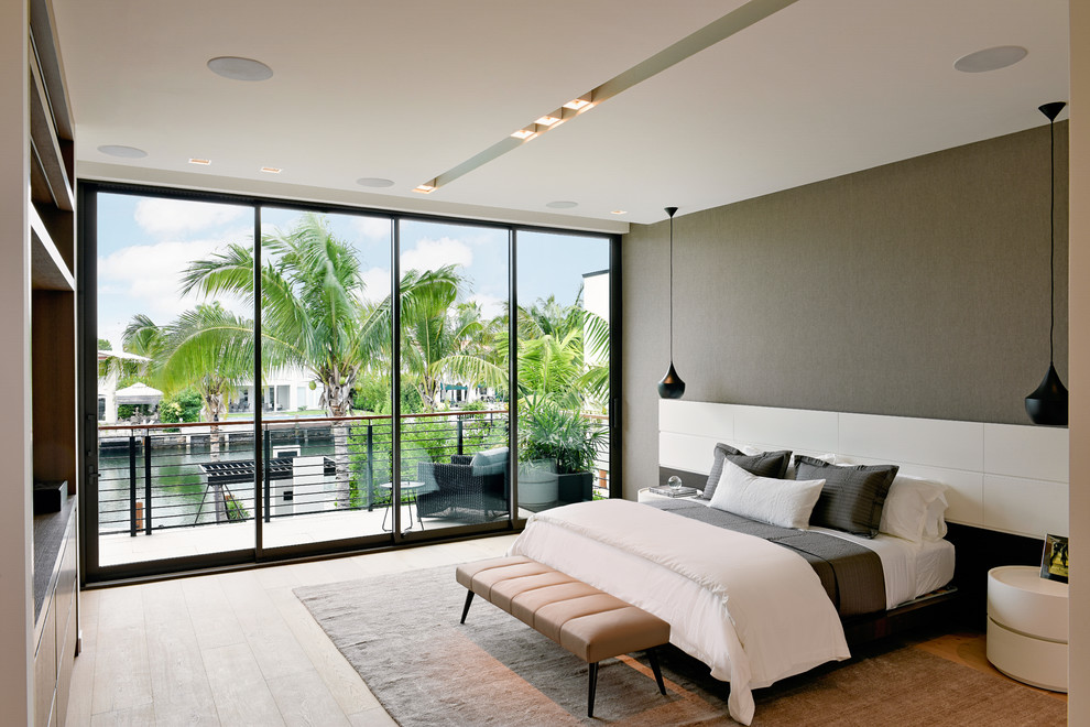 Photo of a contemporary bedroom in Miami with grey walls, light hardwood floors and beige floor.